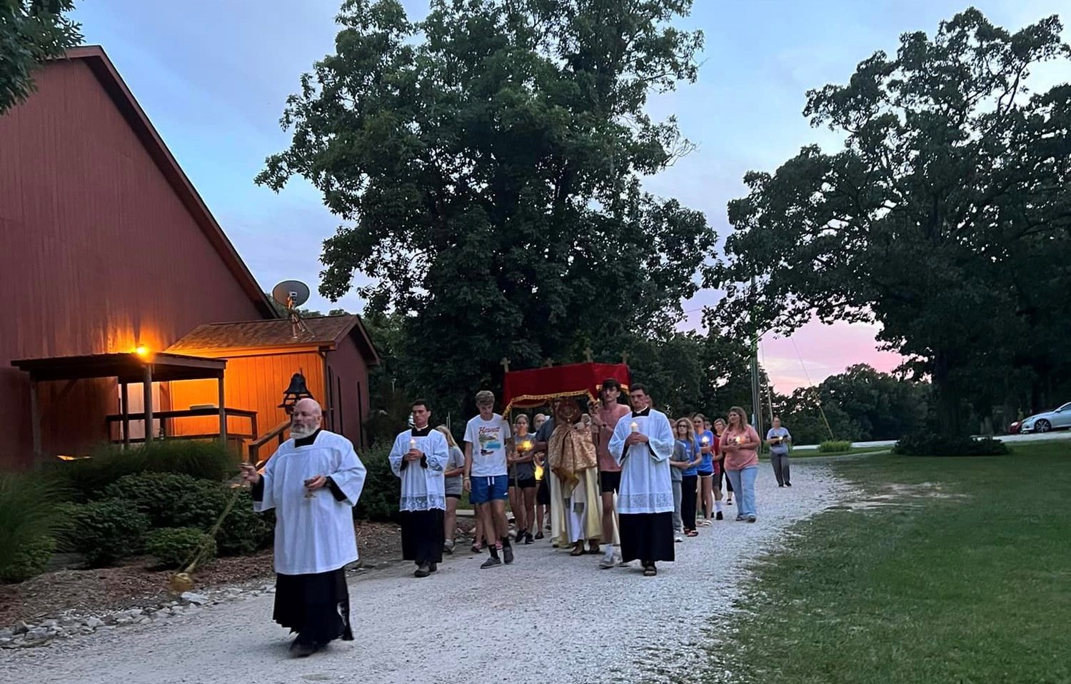 Young people at Camp Tolton take part in a Eucharistic procession into the woods at dusk at Camp Jo’Ota in Clarence.
